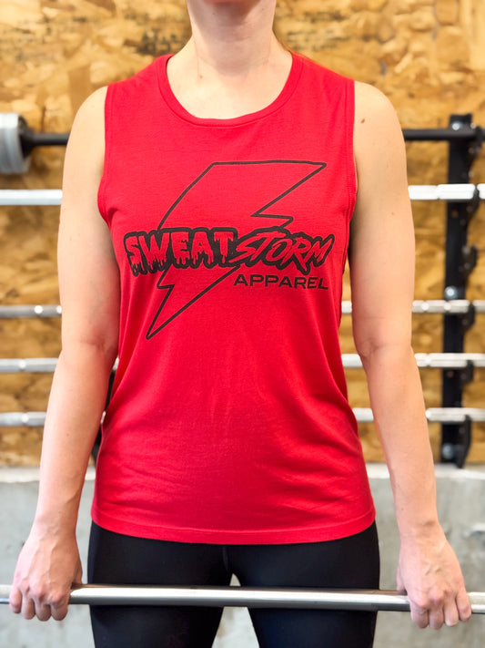 Person wearing a red sleeveless shirt with 'Sweat Storm Apparel' logo in a gym setting